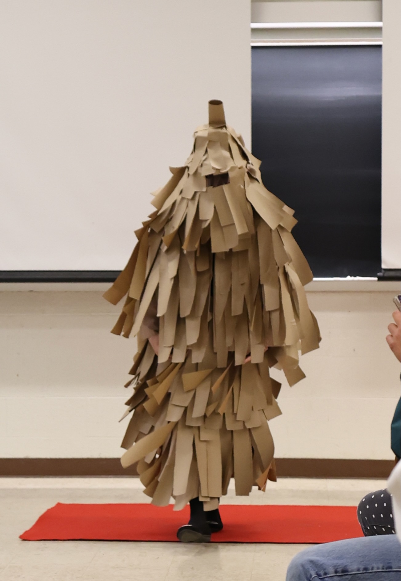 A giant bagworm costume, where the wearer is entirely concealed by large rectangles of brown paper. 